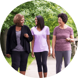Three people walking down a sidewalk